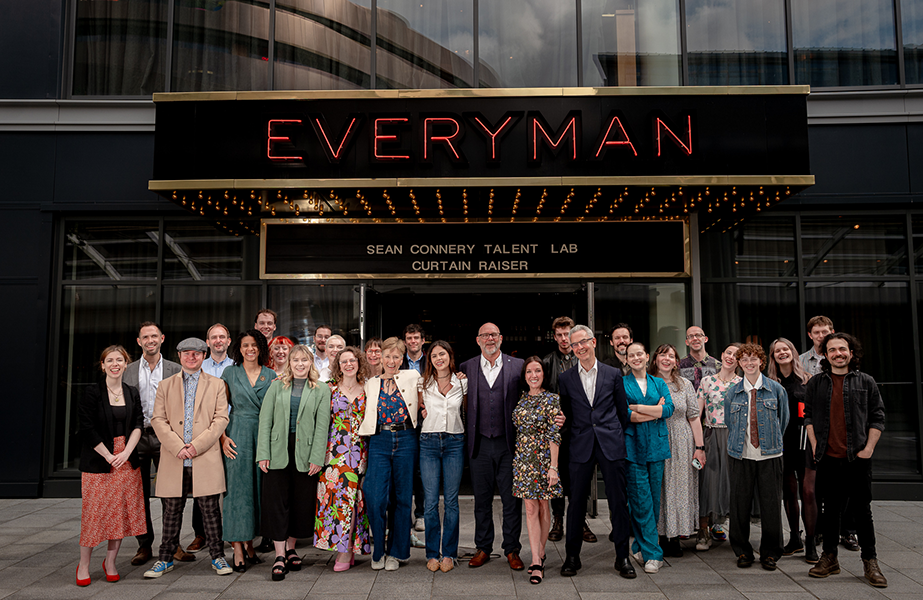 A crowd of people pose for a photograph outside of the Everyman Cinema in London