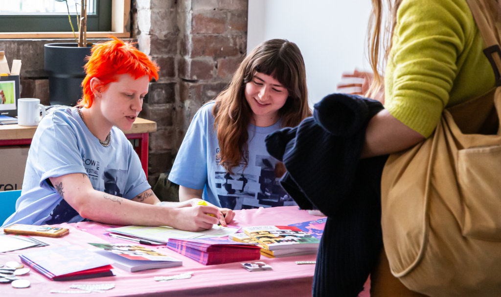 Two volunteers greet a guest at the Glasgow Short Film Festival 2025